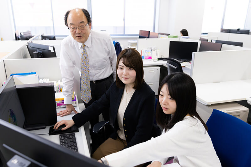 A person who explains things on a computer in an office