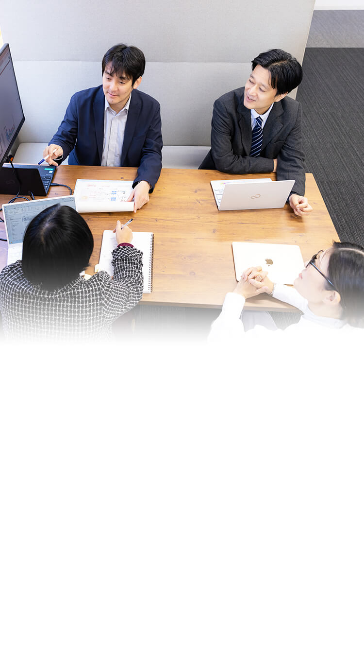 People discussing over a monitor in an office meeting space